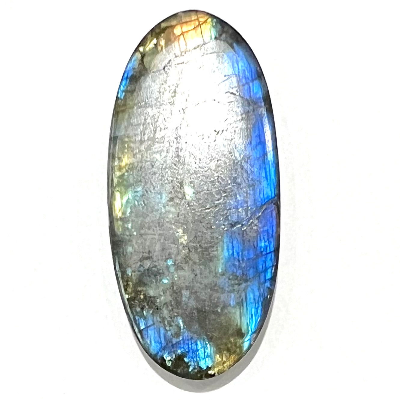 A loose, oval cabochon cut labradorite stone.  The stone is green with bright blue and yellow flashes.