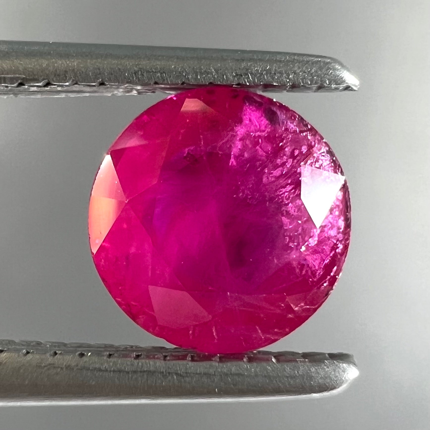 A faceted round brilliant cut Burma ruby gemstone.  The stone is certified as natural by Guild Laboratories.