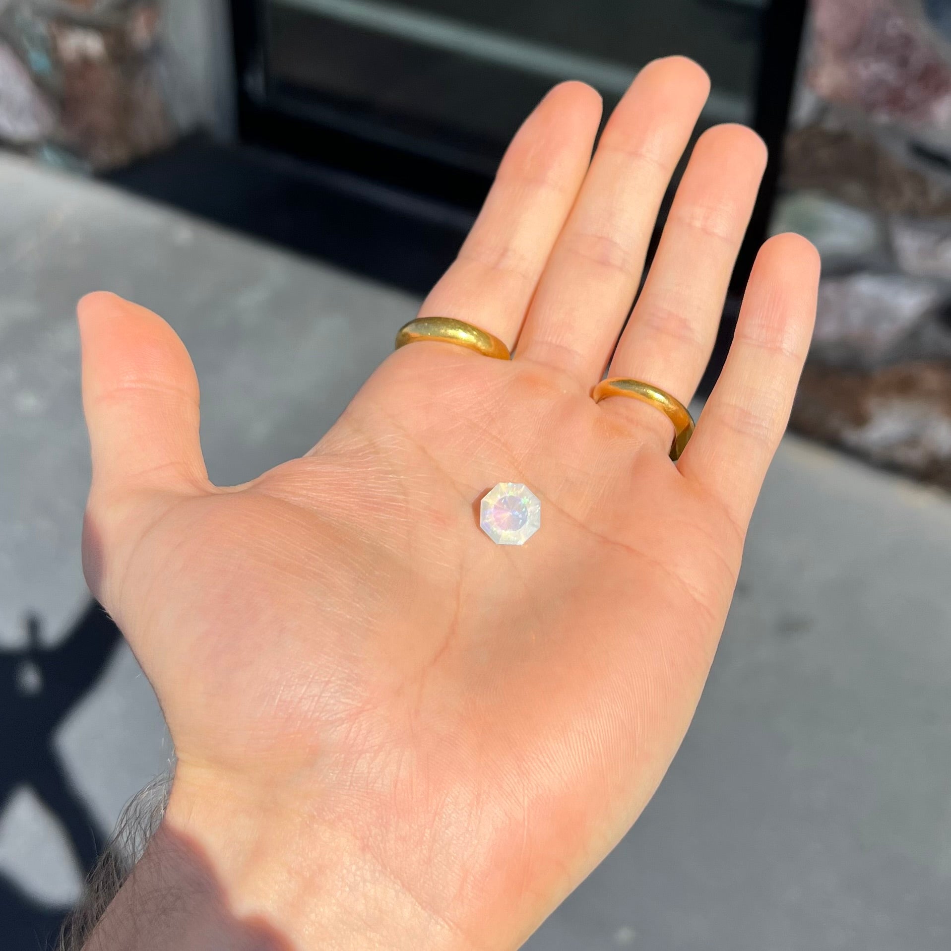 A loose, faceted octagon cut Mexican fire opal gemstone.  The stone is a light yellow color with blue and green fire.