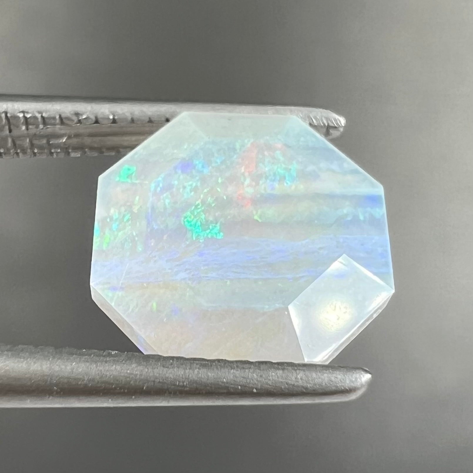 A loose, faceted octagon gray base crystal opal from Lightning Ridge, Australia.