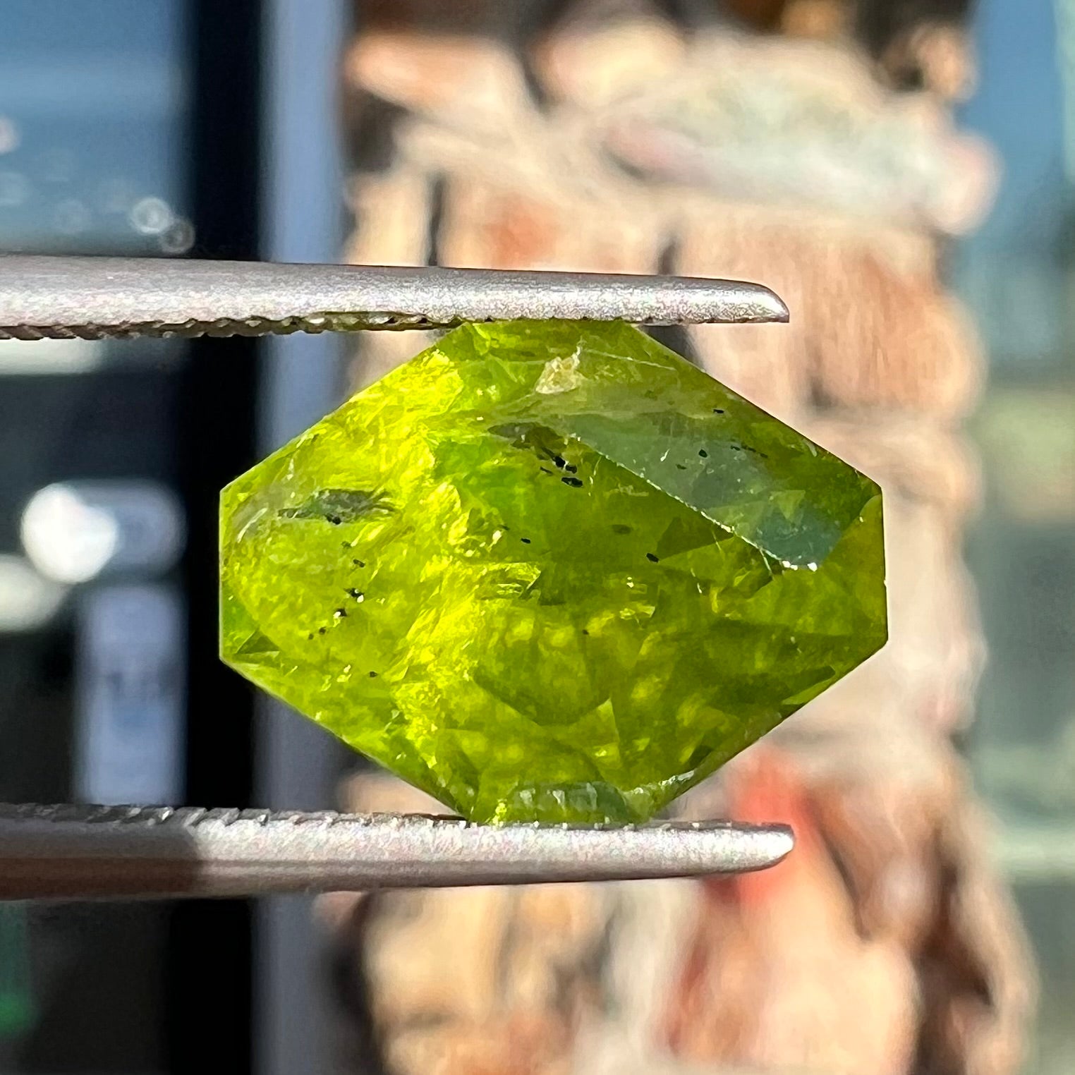 A loose, modified octagon peridot stone.  The stone is a yellow green color.