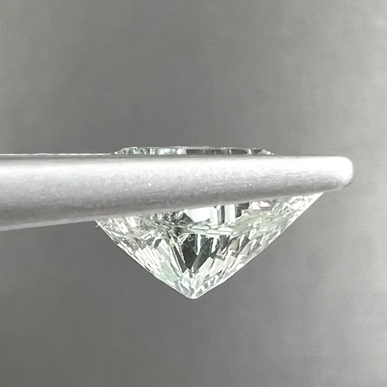 A loose, triangular fantasy cut prasiolite gemstone.  Prasiolite is a light green variety of quartz.