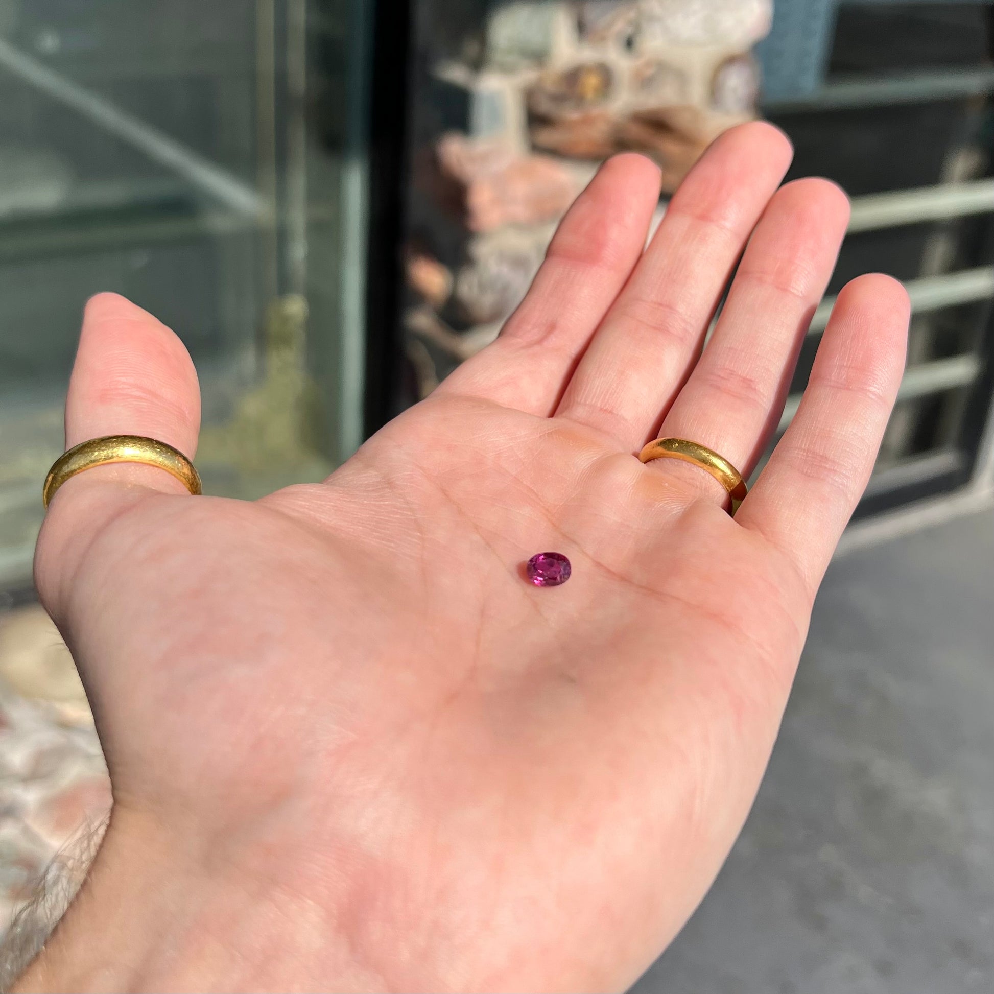 A loose, faceted oval cut natural purple sapphire.  The stone has a burst crystal inclusion.