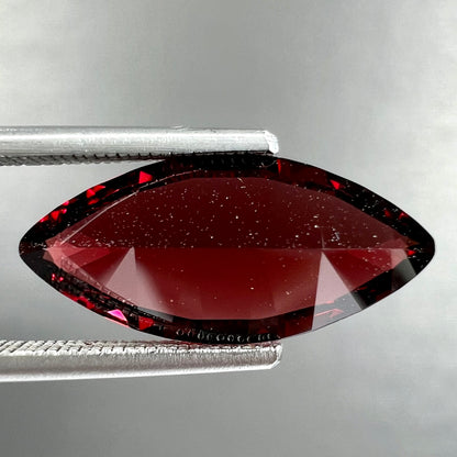 A faceted marquise cut red pyrope garnet stone.