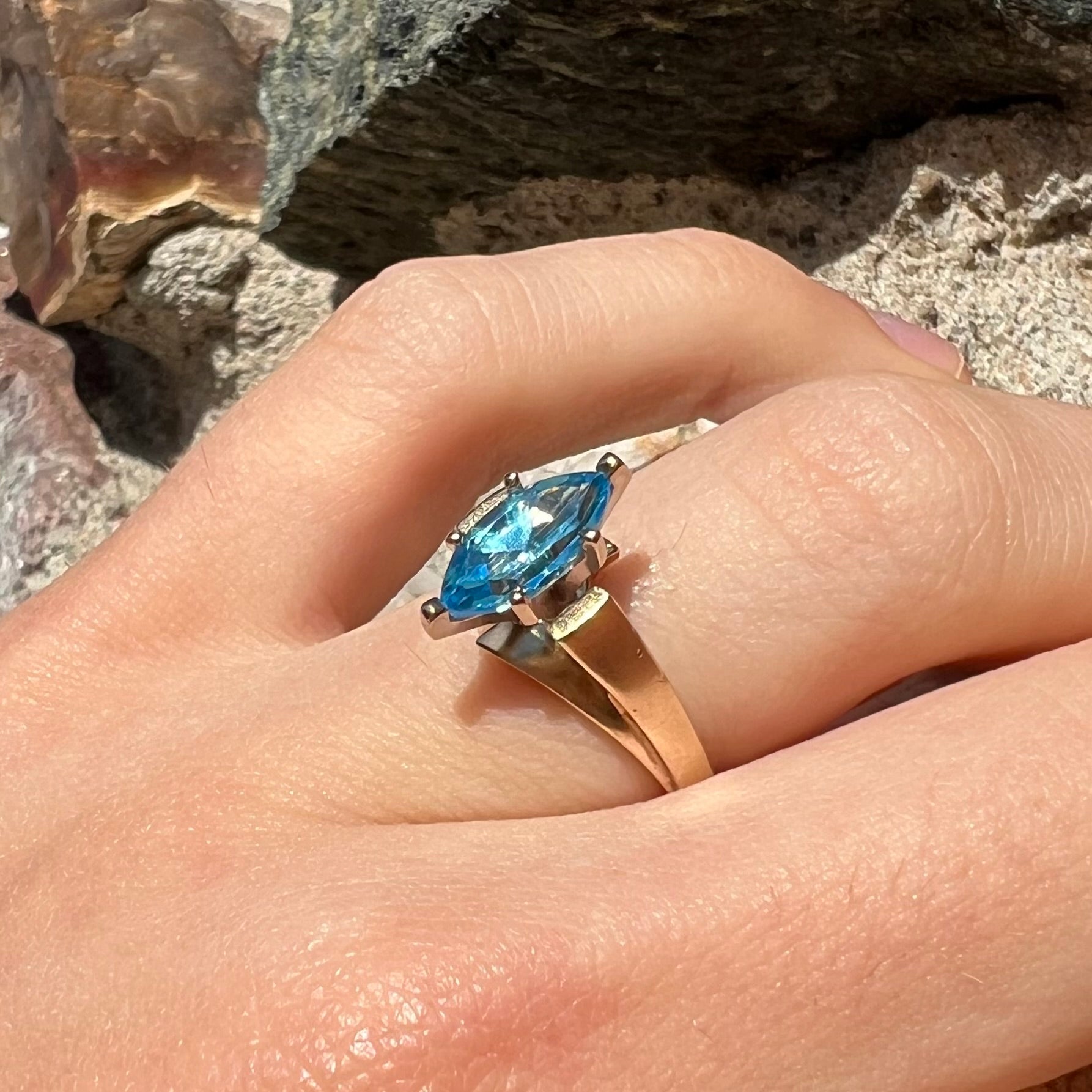 A ladies' estate yellow gold ring, prong set with a marquise cut blue topaz stone.  There are scratches on the shank.