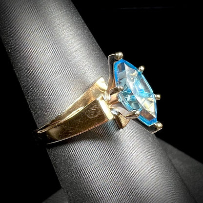 A ladies' estate yellow gold ring, prong set with a marquise cut blue topaz stone.  There are scratches on the shank.