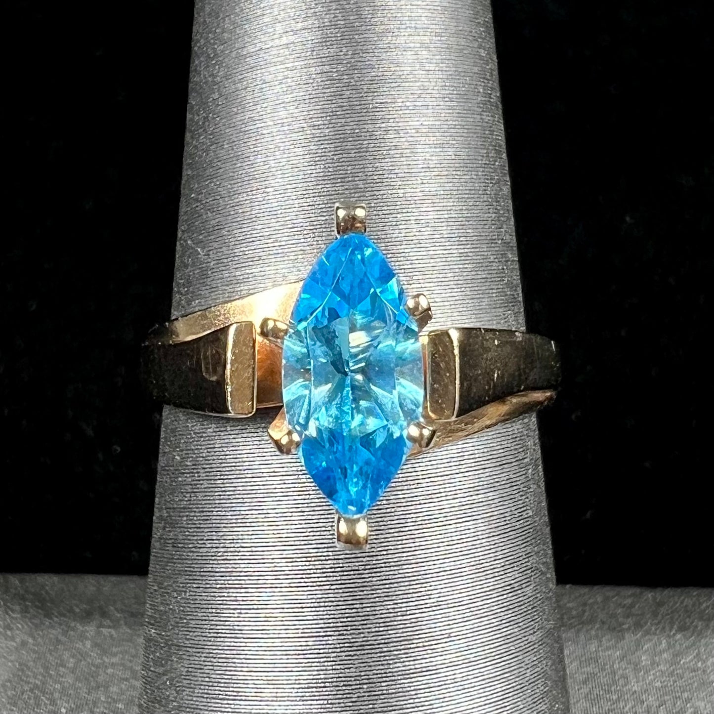 A ladies' estate yellow gold ring, prong set with a marquise cut blue topaz stone.  There are scratches on the shank.