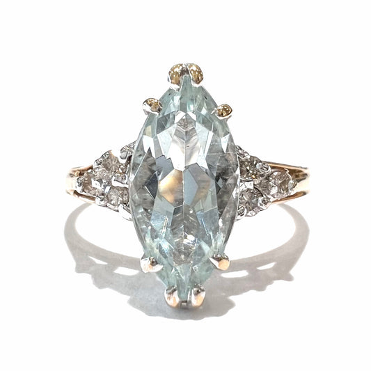 A ladies' ring set with a marquise cut aquamarine and round accent diamonds.