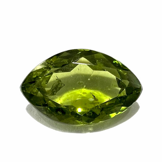 A loose, marquise cut peridot gemstone.  The stone is an olive green color.