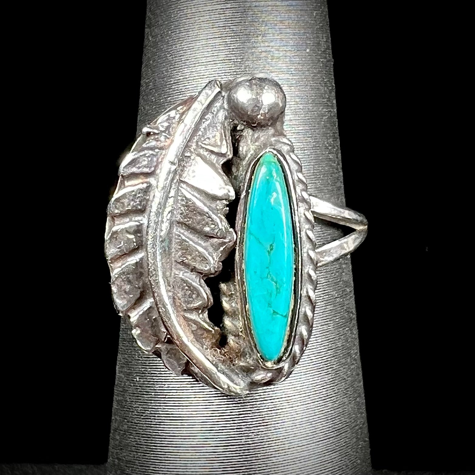 A ladies' sterling silver feather style ring set with a marquise cut turquoise stone.