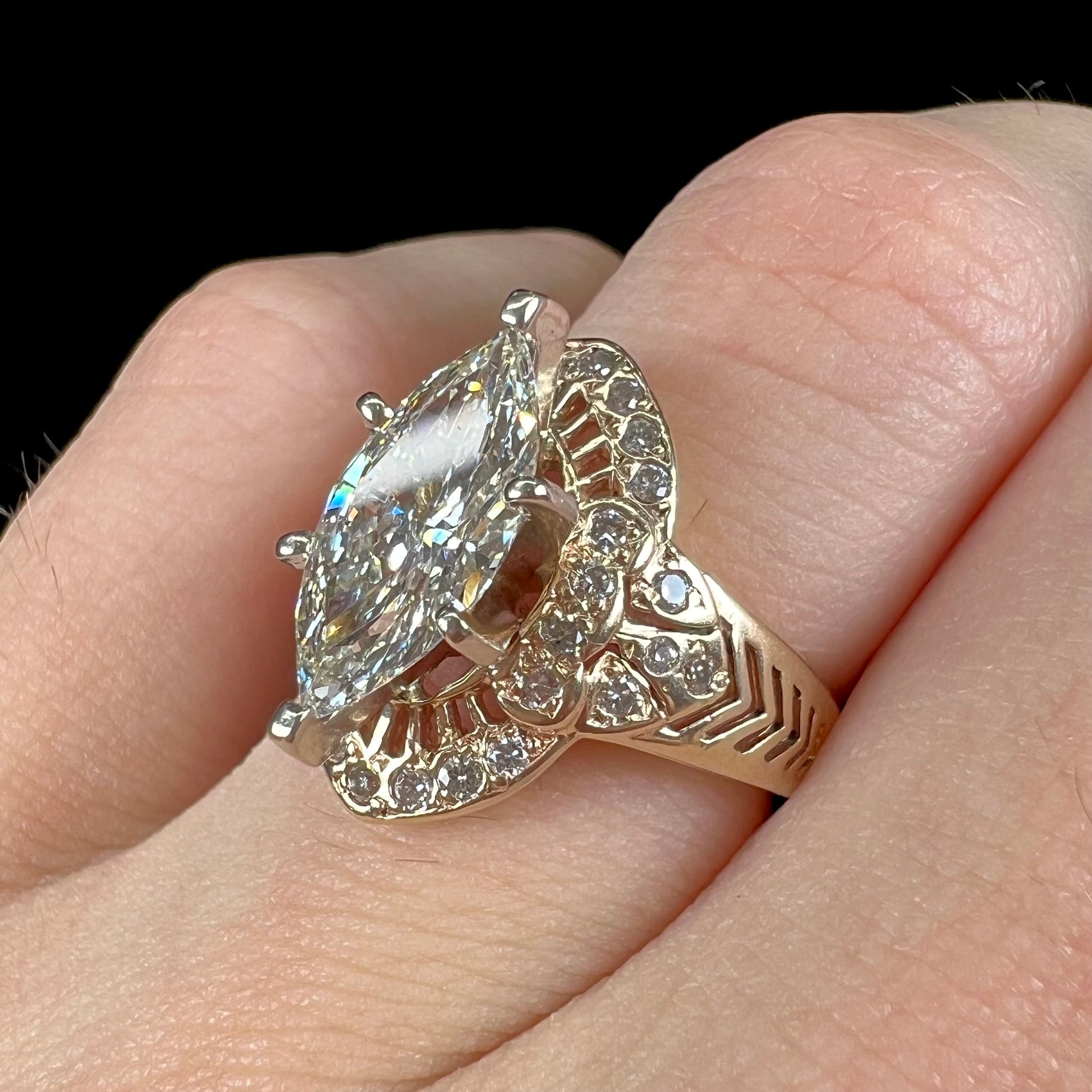 A ladies' yellow gold engagement ring set with a 1.54ct marquise cut natural diamond with round diamond accents.