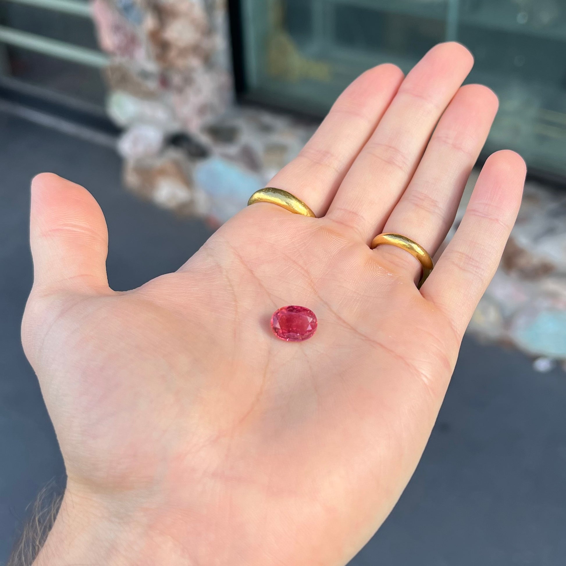 A faceted, oval cut, melon pink tourmaline gemstone.