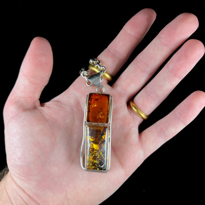 A sterling silver pendant set with two rectangle shaped natural amber cabochons.
