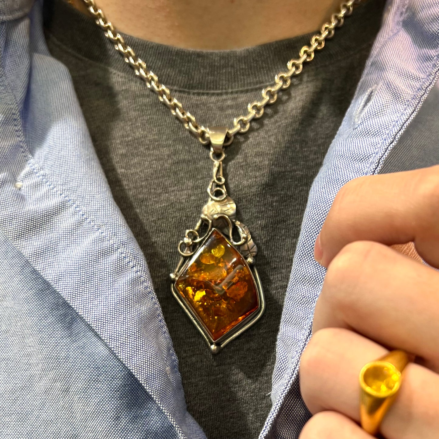 Unisex silver pendant set with a sun-spangled Mexican amber stone, featuring silver leaf design accents.