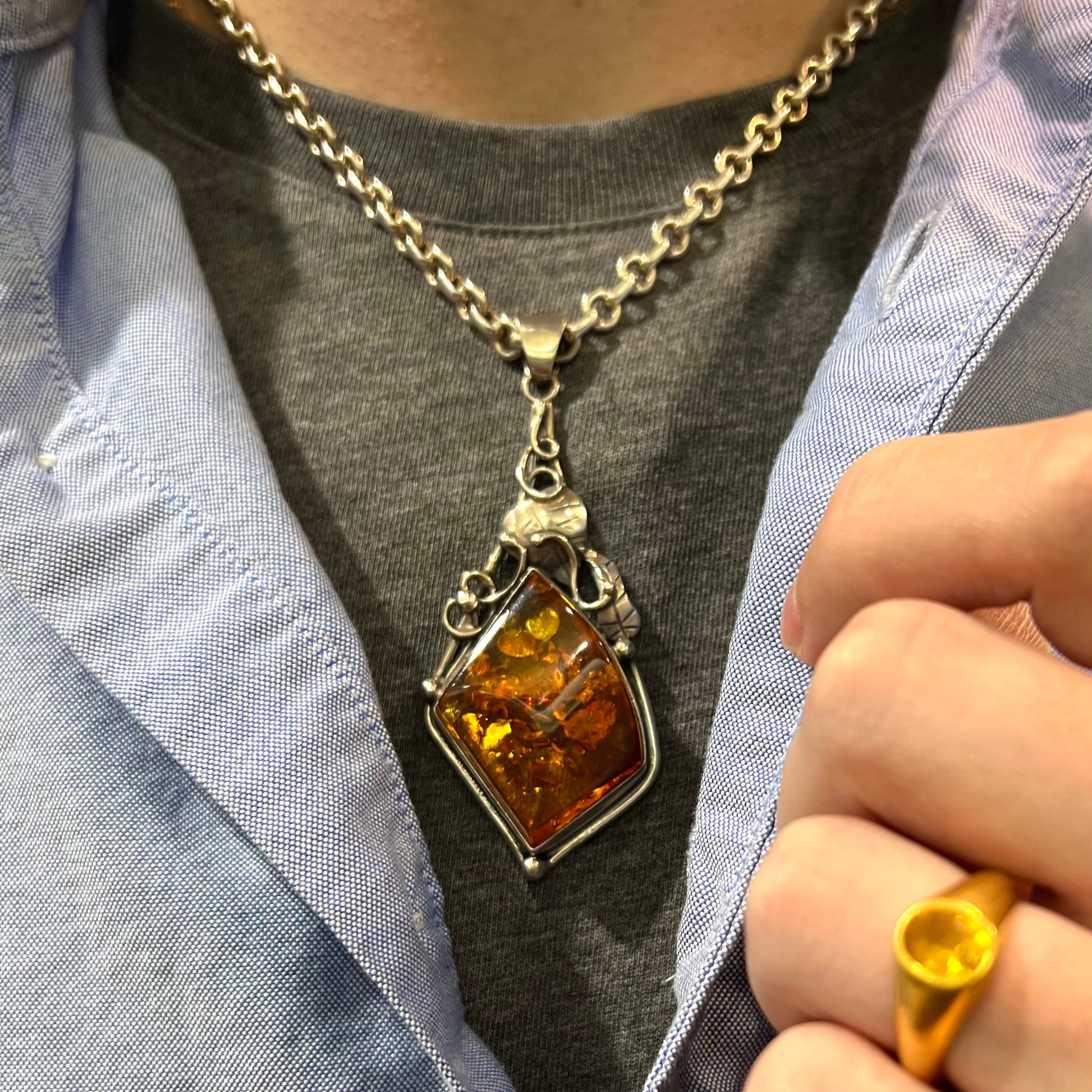 Unisex silver pendant set with a sun-spangled Mexican amber stone, featuring silver leaf design accents.