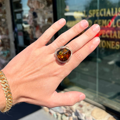 Unisex sterling silver ring set with a large sun-spangled Baltic amber gemstone.