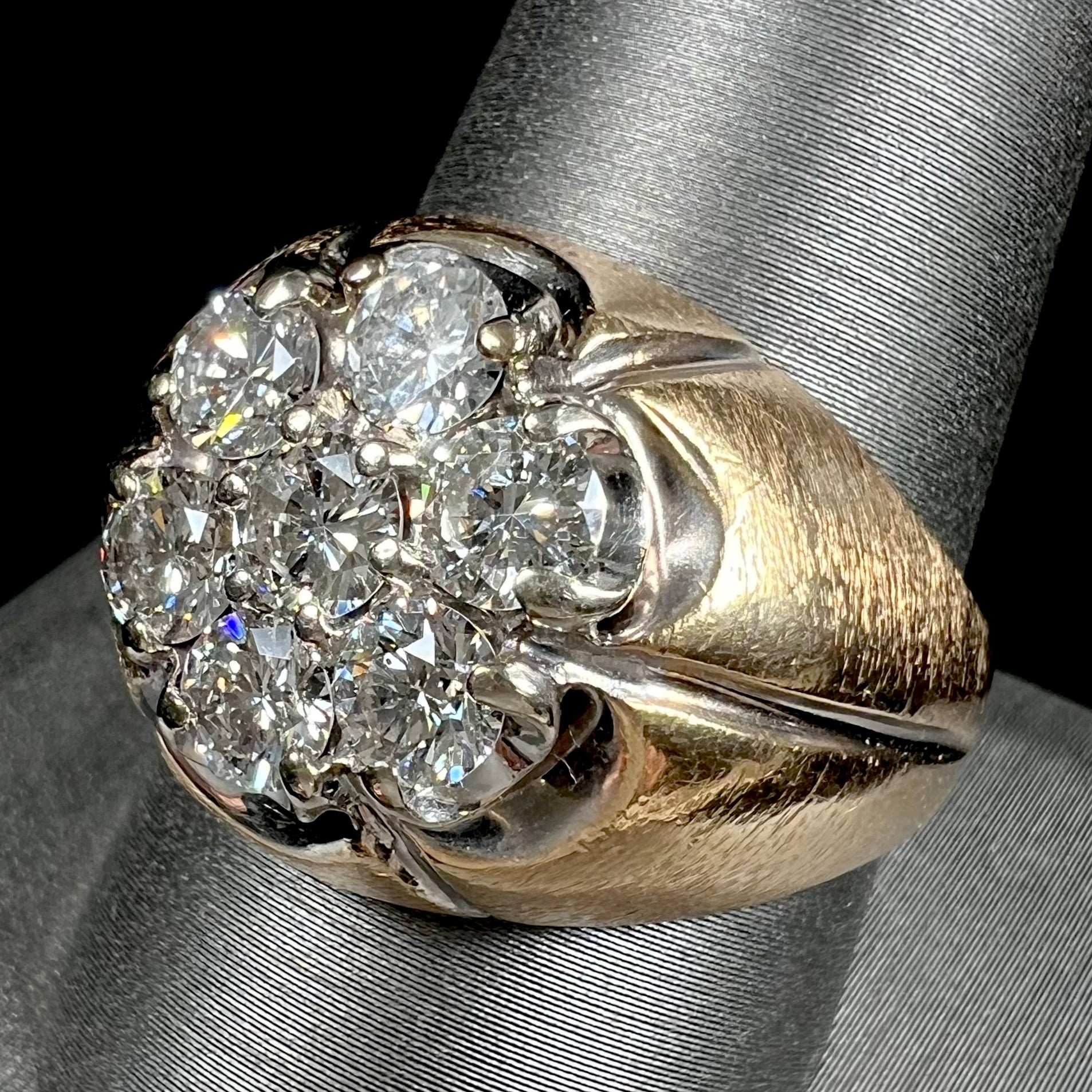 A men's textured yellow gold ring set with a cluster of seven round brilliant cut natural diamonds.