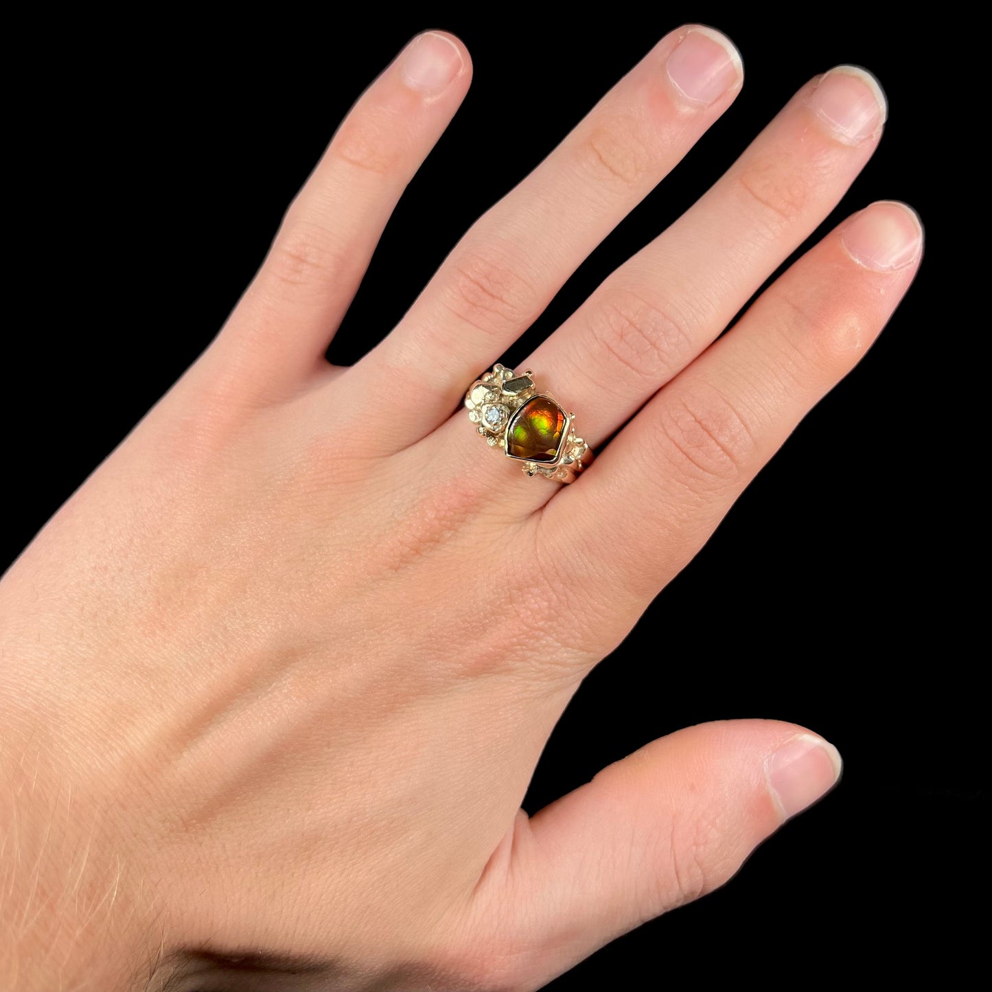 A men's yellow gold, nugget style ring set with a Mexican fire agate stone and a diamond accent.