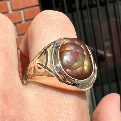 A men's solid yellow gold ring set with a Mexican fire agate stone.  The fire agate has a puple bull's eye pattern.