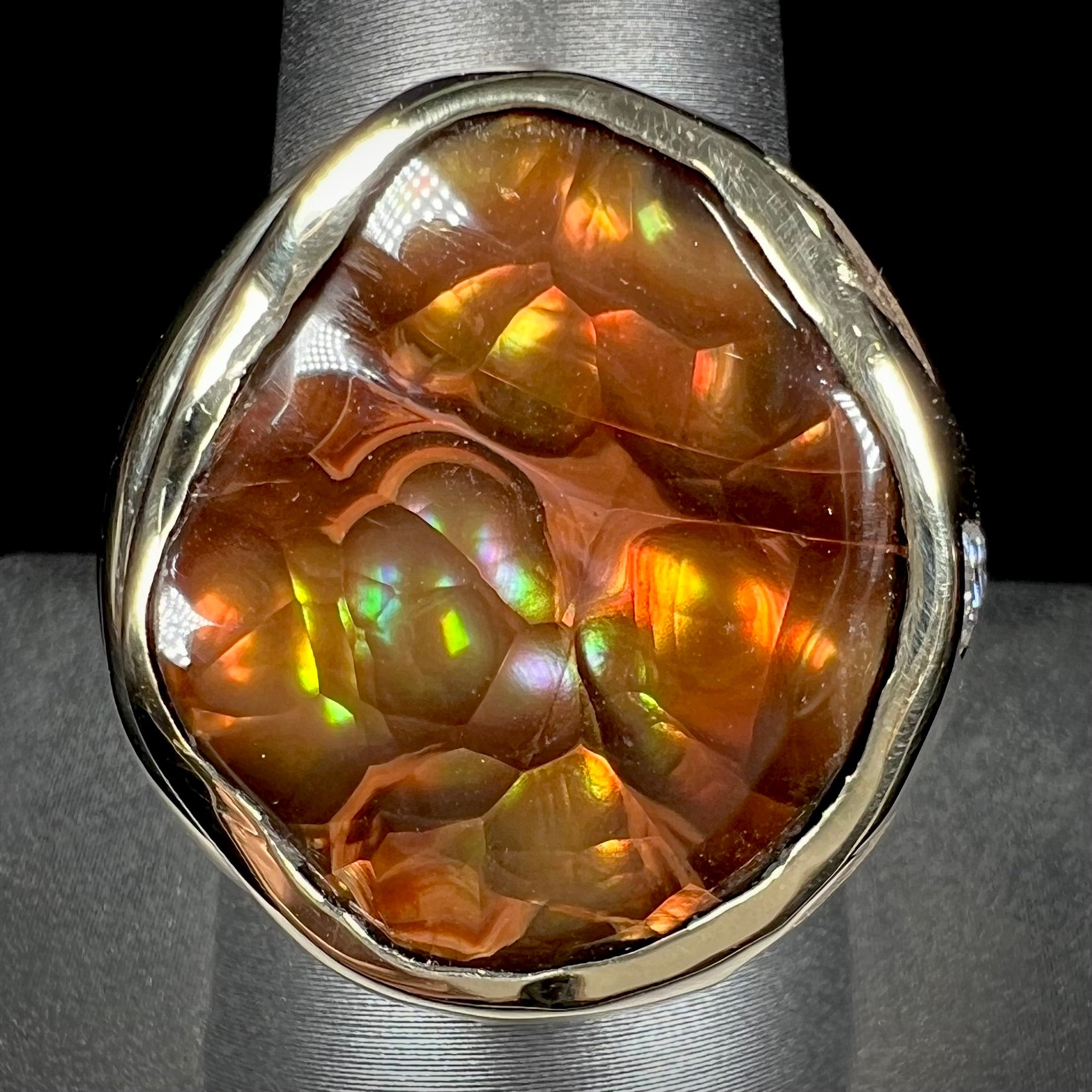 A men's heavy yellow gold ring set with a Mexican fire agate stone and three round brilliant cut diamond accents.