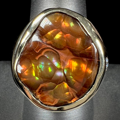 A men's heavy yellow gold ring set with a Mexican fire agate stone and three round brilliant cut diamond accents.