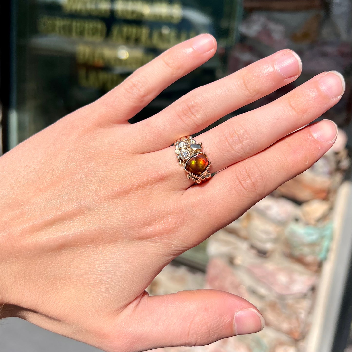 A men's yellow gold, nugget style ring set with a Mexican fire agate stone and a diamond accent.