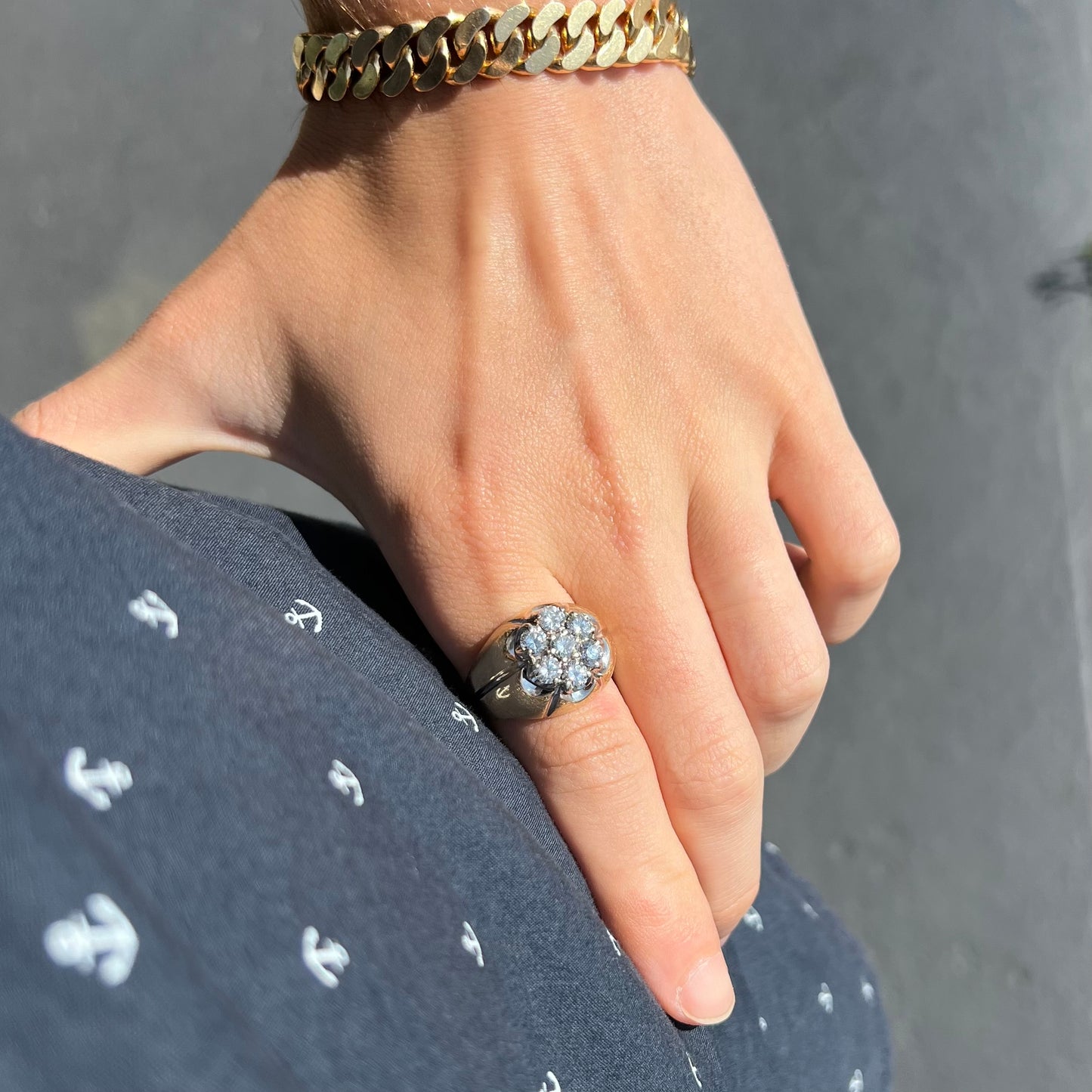 A men's textured yellow gold ring set with a cluster of seven round brilliant cut natural diamonds.