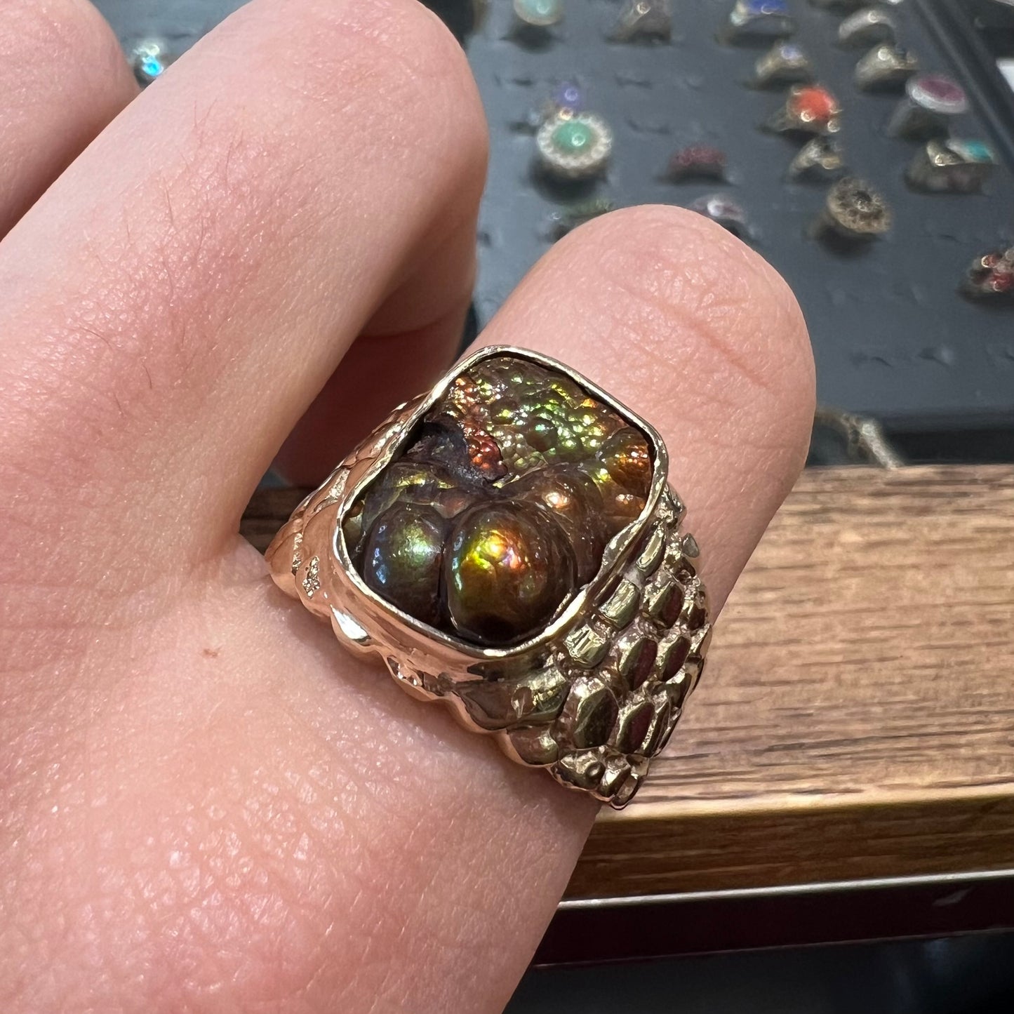 A men's yellow gold, nugget style ring set with a bubbly, California fire agate stone.