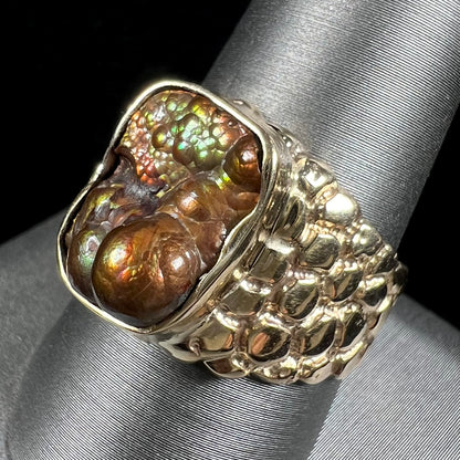 A men's yellow gold, nugget style ring set with a bubbly, California fire agate stone.