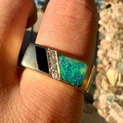 A men's yellow gold ring inlay set with onyx, natural black opal, and four diamonds.