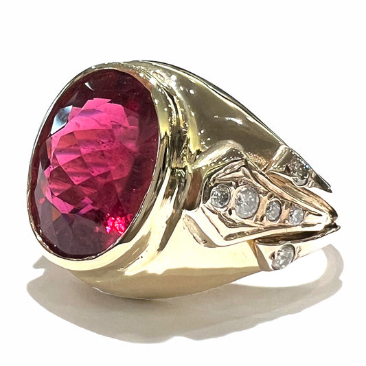 A men's yellow gold ring set with an oval cut rubellite tourmaline with diamond accents.