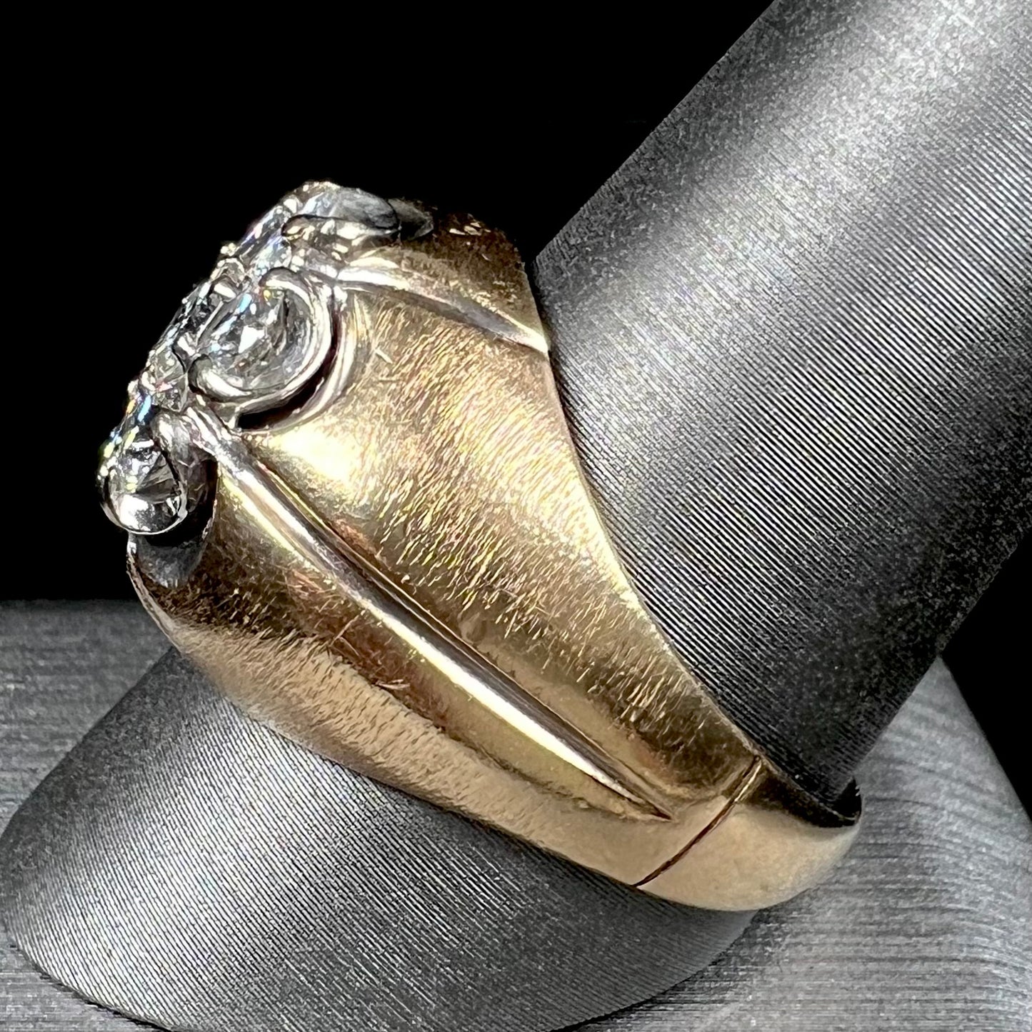 A men's textured yellow gold ring set with a cluster of seven round brilliant cut natural diamonds.