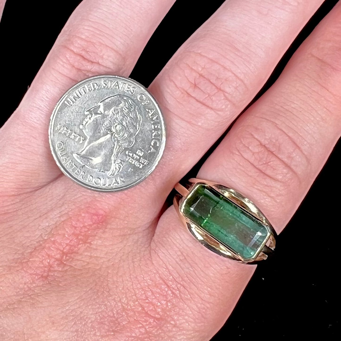 A men's emerald cut tricolor tourmaline solitaire ring in yellow gold.  The tourmaline shifts from green to blue green to blue.