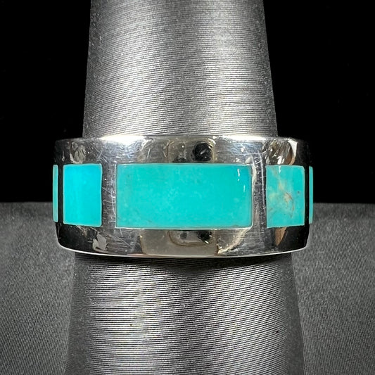 A men's sterling silver wedding band inlaid with natural Sleeping Beauty Turquoise stones that go all the way around.