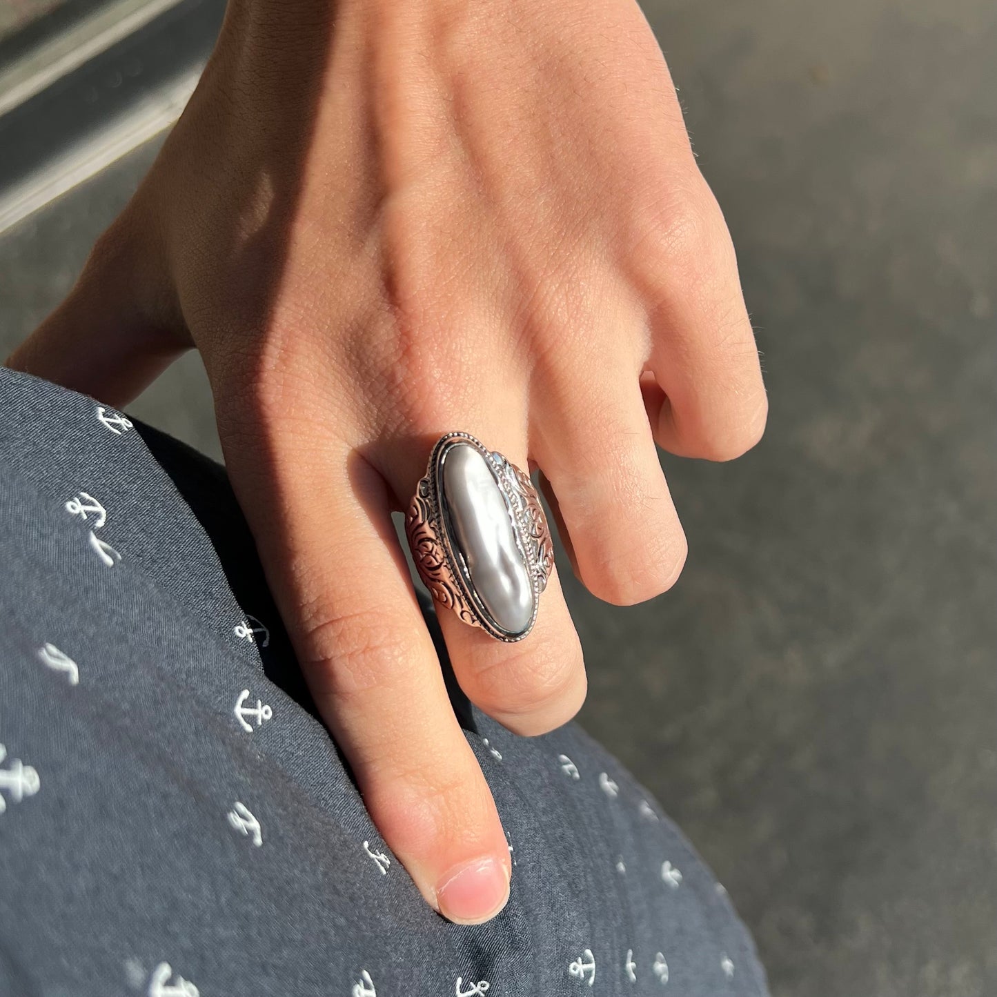 A Boho Chic style sterling silver solitaire ring set with an oval shaped, metallic silver gray mabe pearl.