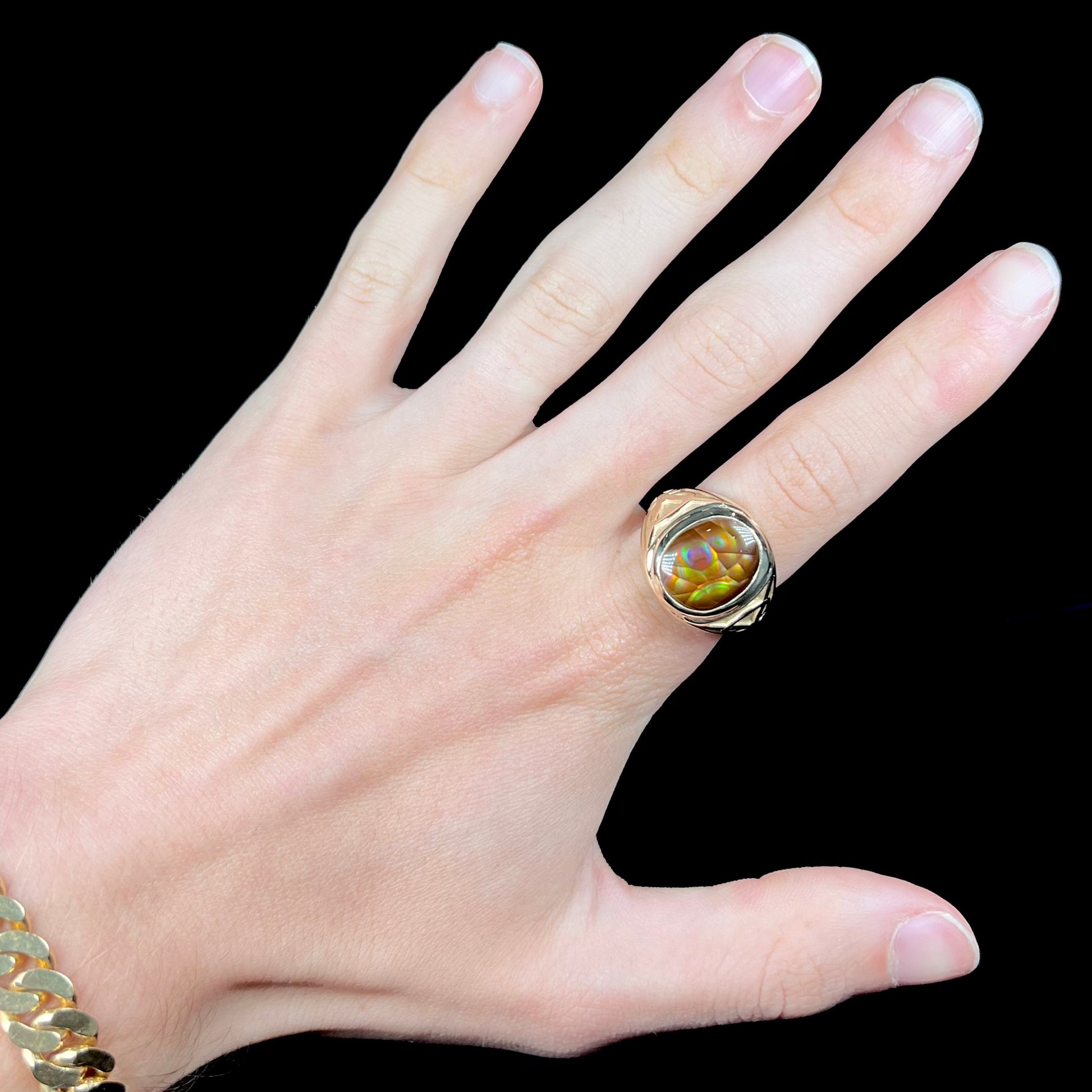 A men's solid yellow gold ring set with a Mexican fire agate stone.  The fire agate has a puple bull's eye pattern.