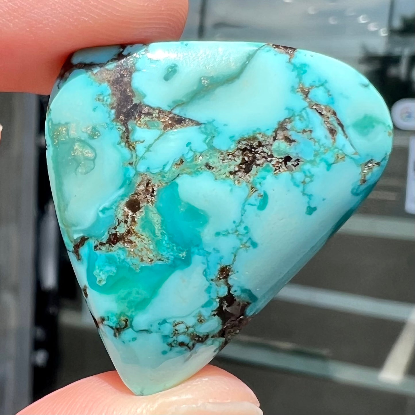 A loose, freeform triangular cabochon cut turquoise stone from Sonora, Mexico.