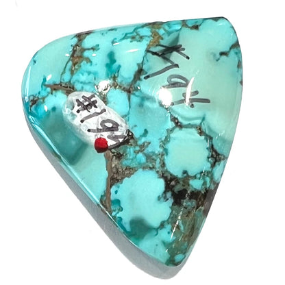 A loose, freeform triangular cabochon cut turquoise stone from Sonora, Mexico.