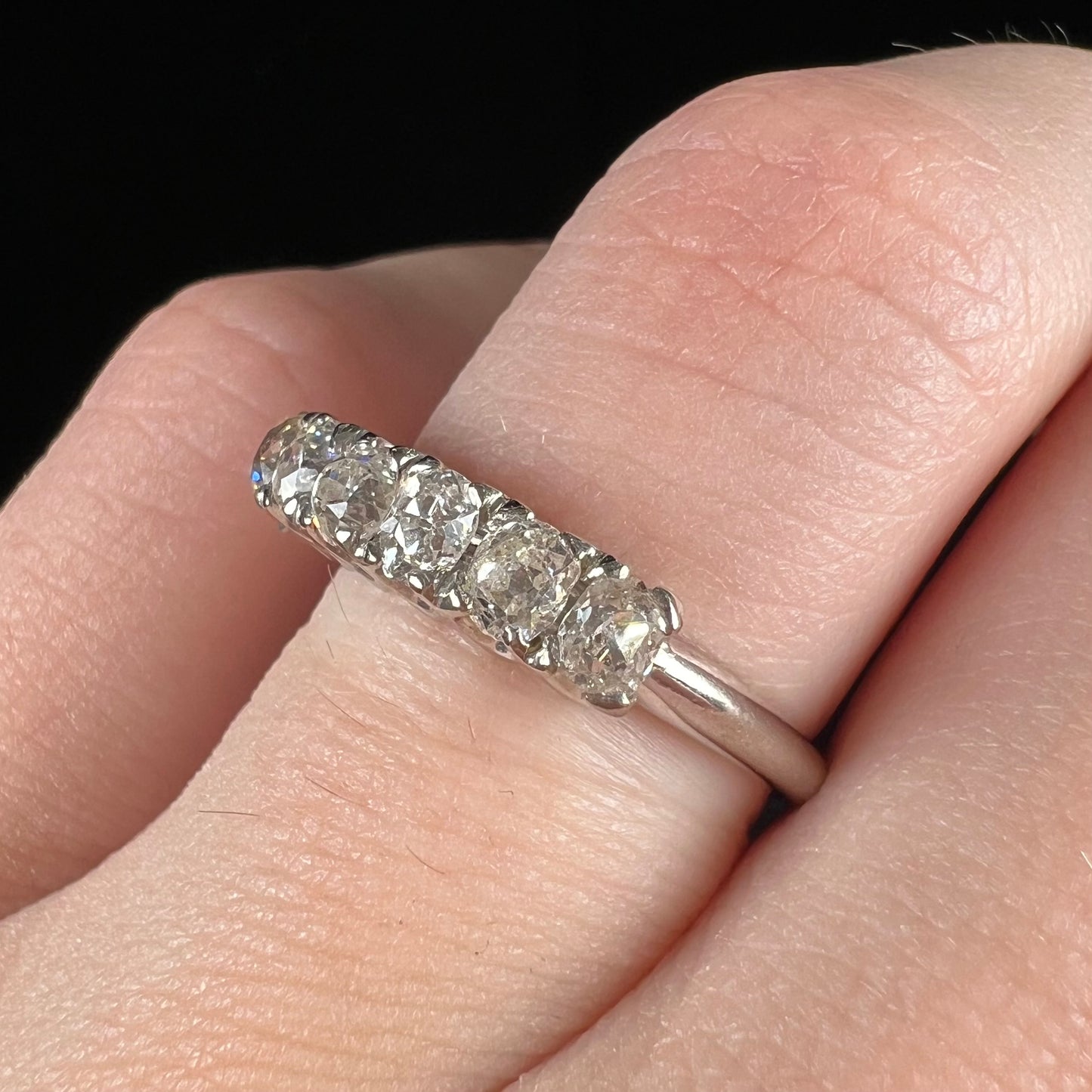 An antique white gold diamond wedding band set with six old mine cut natural diamonds.