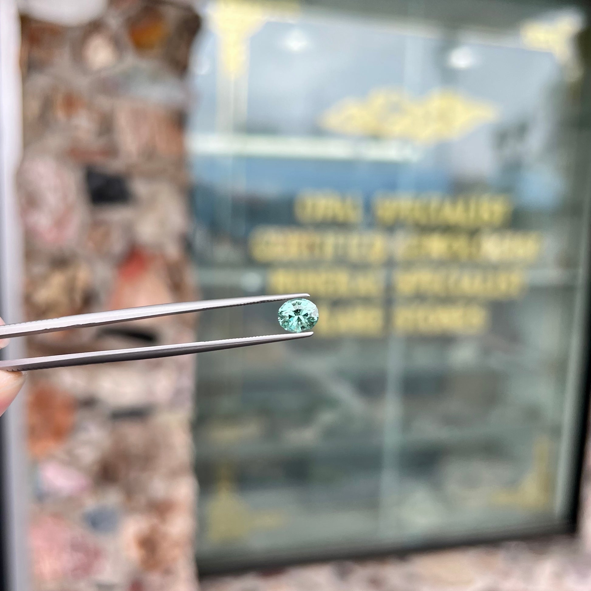 A loose, faceted modified oval cut mint green tourmaline gemstone.