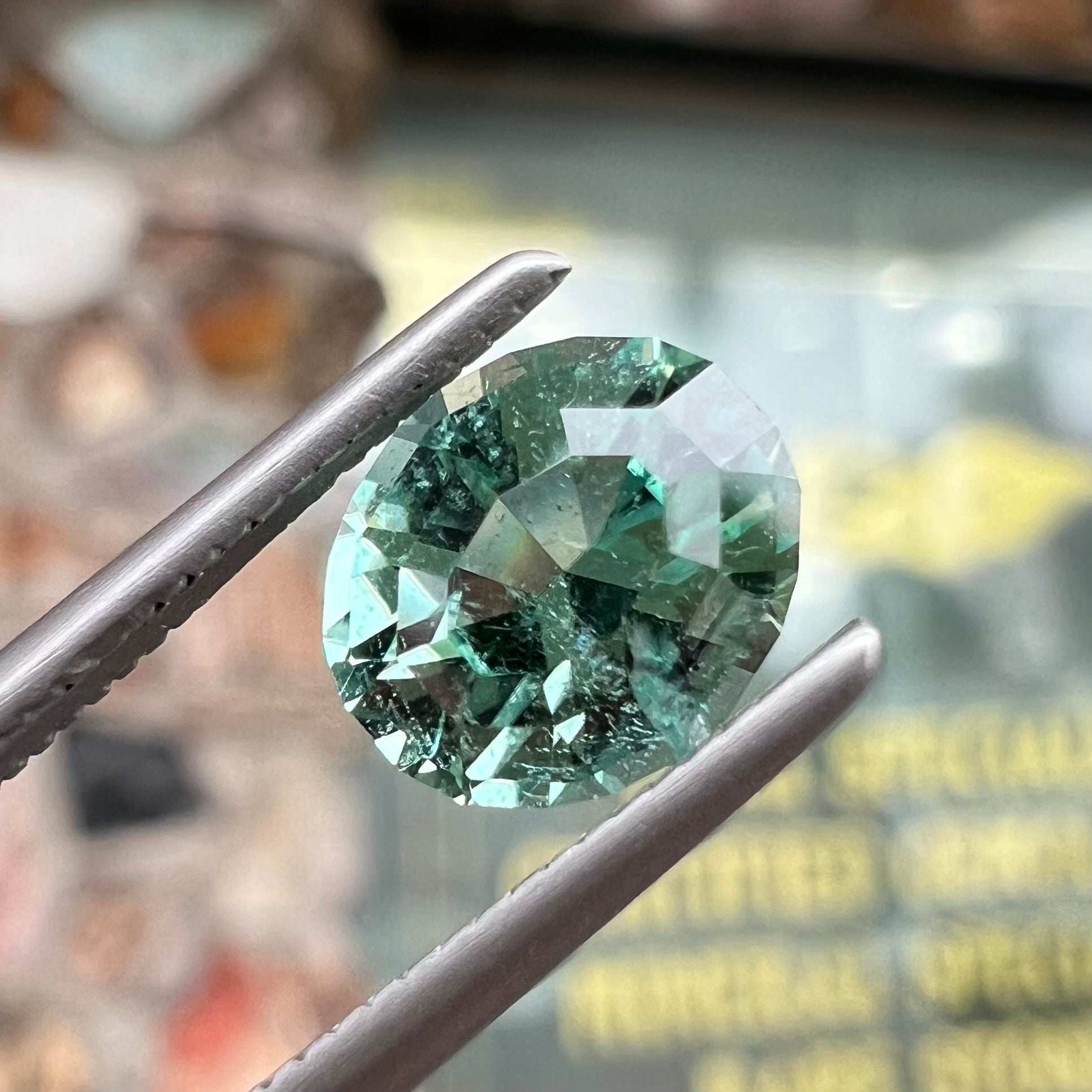 A loose, faceted modified oval cut mint green tourmaline gemstone.