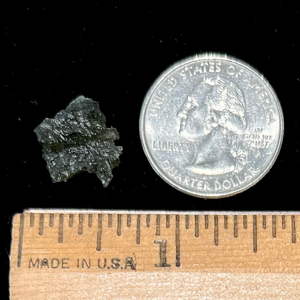 A natural, rough moldavite crystal.  The stone is green color and transluscent.