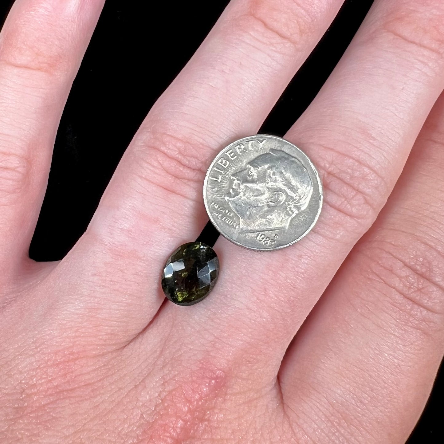 A loose, faceted oval checkerboard moldavite gemstone from the Czech Republic.