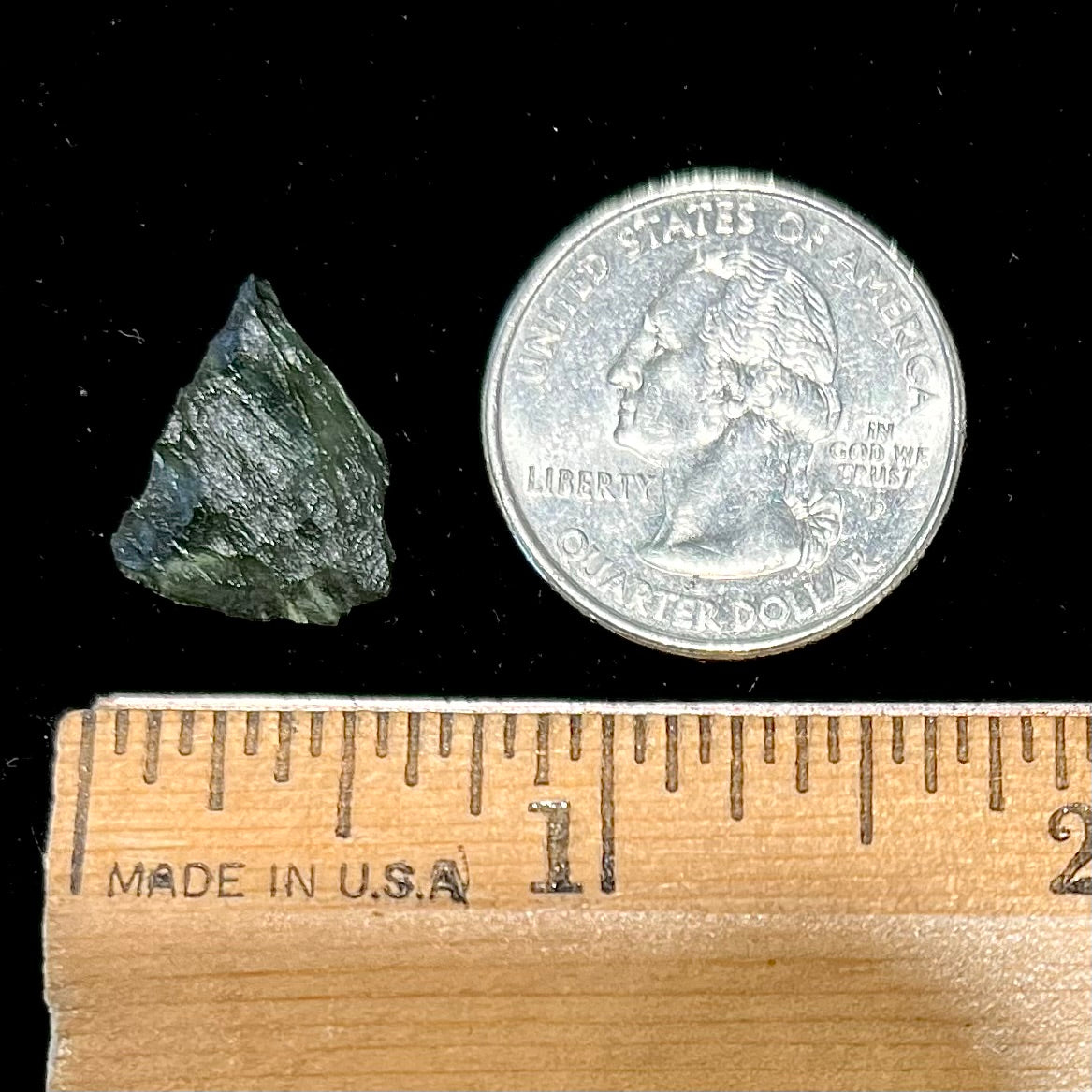 A natural, rough moldavite crystal.  The stone is green color and transluscent.