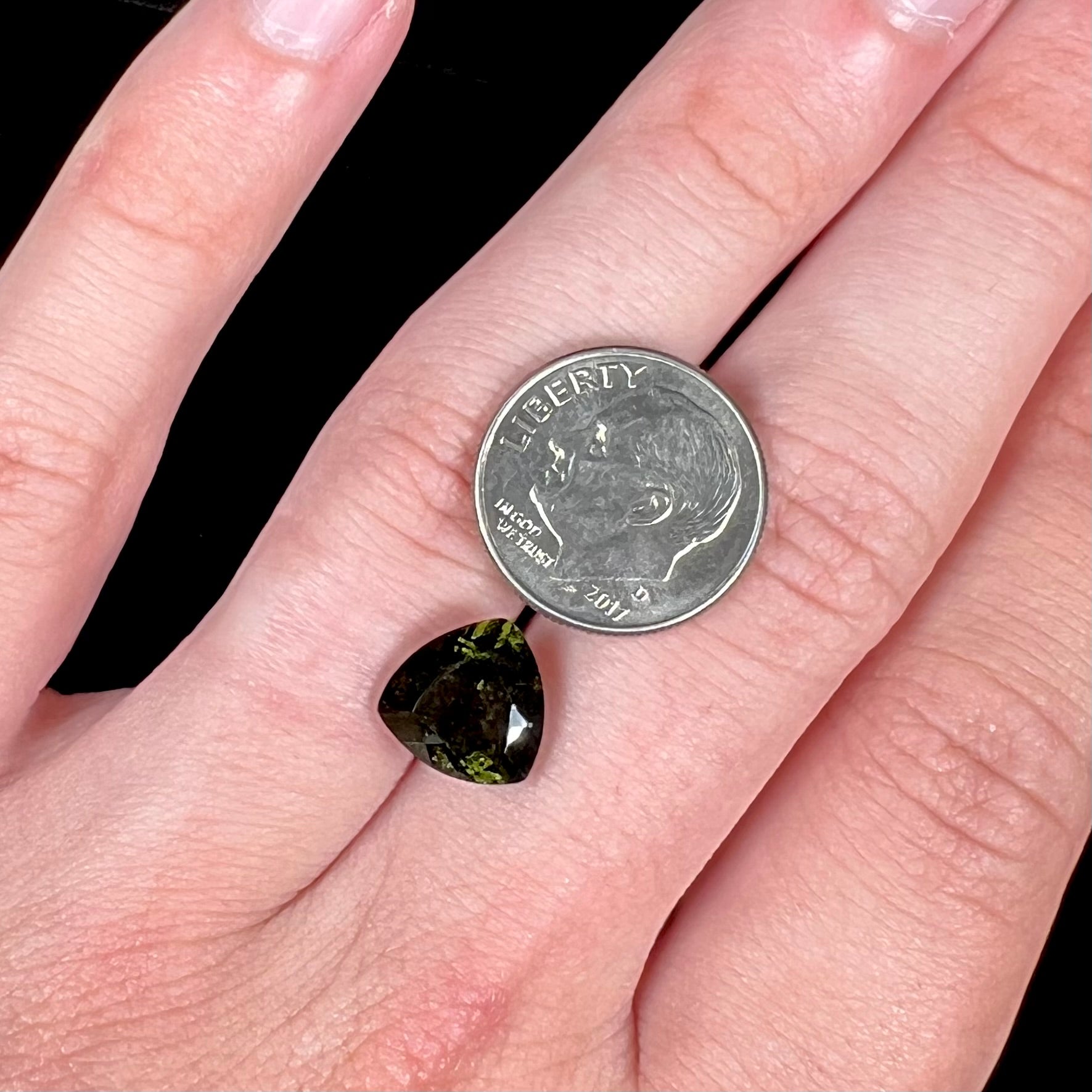A natural, trillion cut moldavite gemstone.