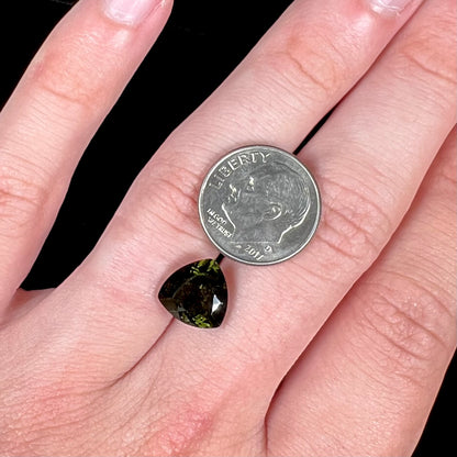 A natural, trillion cut moldavite gemstone.