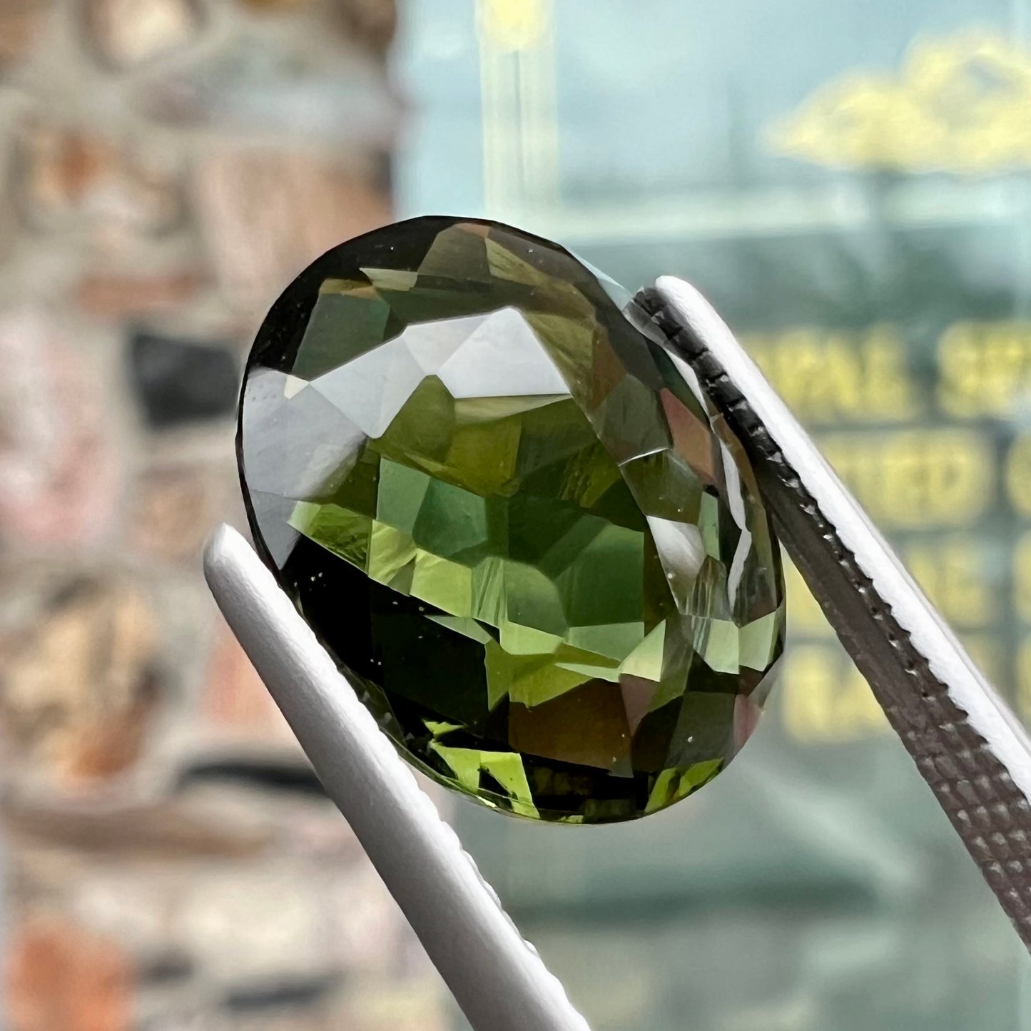 A loose, oval cut natural moldavite gemstone.  The stone weighs 3.85 carats.