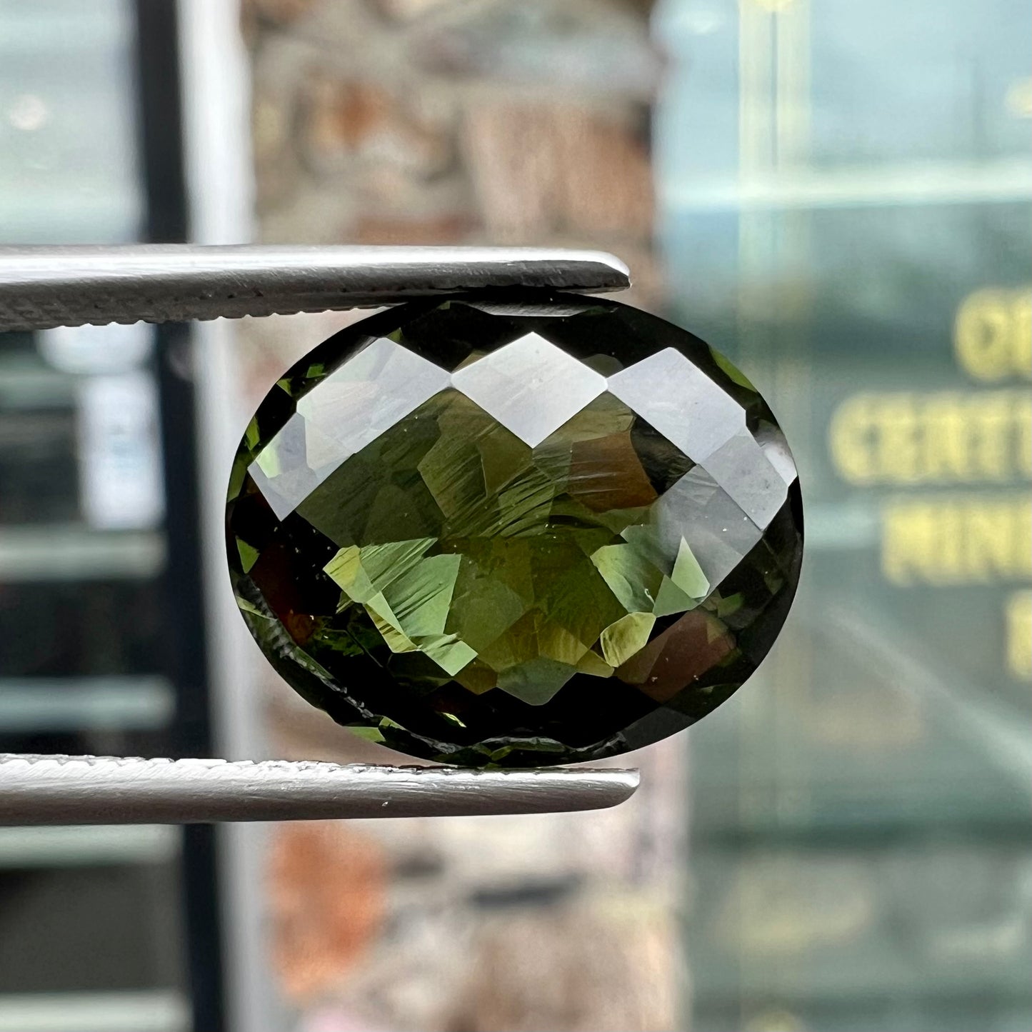 A loose, oval cut natural moldavite gemstone.  The stone weighs 3.85 carats.