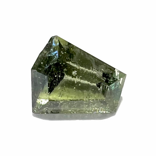 A loose, shield cut, natural moldavite gemstone.  The stone has a small chip in the top corner facet.