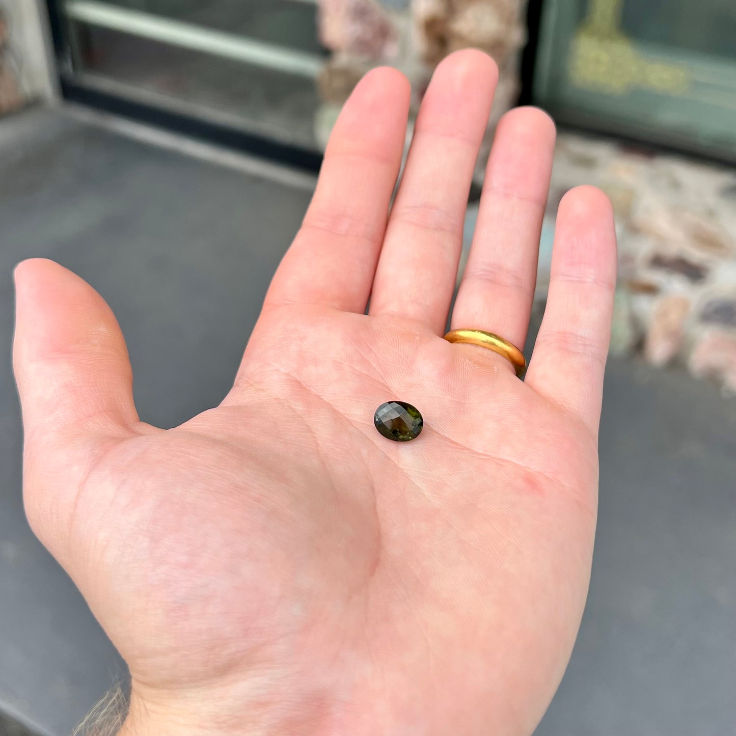 A loose, faceted oval checkerboard moldavite gemstone from the Czech Republic.